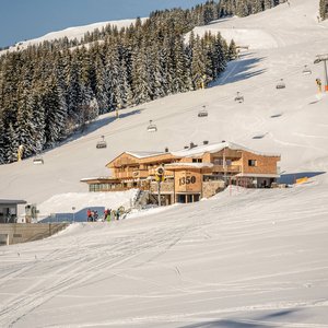 Außenaufnahme von der Alm 1350 im Winter mit Skipiste und Sessellift